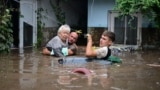 Residents assist an elderly woman as floodwaters rise in Slobozia Conachi, Romania, on September 14.<br />
<br />
The floods, which have claimed at least 10 lives from Poland to Romania, have submerged towns and homes, triggering large-scale evacuations.