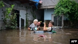 Местни спасяват възрастна жена в румънско село, след като бурята Борис предизвика големи наводнения в Централна и Източна Европа, 14 септември, 2024 г. Стихията причини смъртта на няколко души в Румъния и засегна около 5000 домове в страната.