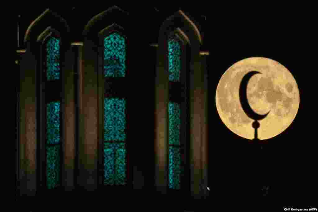 Полная луна светит за Московской Соборной мечетью в российской столице