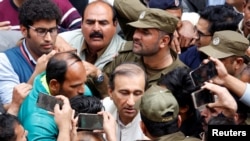 Police officers and media persons gather around Mir Shakil-ur-Rehman, outside a court in the eastern city of Lahore in March. (file photo)