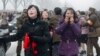 Mourners react as a car carrying Kim Jong Il's body passes by during the funeral procession in Pyongyang on December 28.