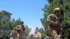 Afghan security officials take positions during a gunbattle between Taliban suicide bombers and Afghan security officials in Lashkar Gah, the provincial capital of Helmand province, May 13, 2015