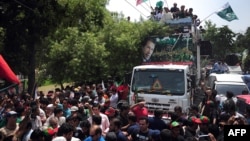 Pakistani cricketer-turned-politician Imran Khan (on truck, center) heads a protest march from Lahore to Islamabad against the government, in Lahore, on August 14.