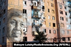 Портрет вчительки української мови Марини Марченко в Авдіївці на стіні багатоповерхівки, обстріляної артилерією