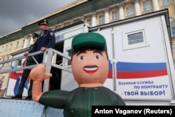 Az orosz hadsereg katonái állnak egy mobil toborzóközpont előtt Szentpétervárott