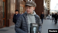  Момче държи книга с лика на Горбачов в Москва, 3 септември 2022 година 