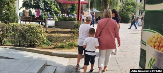Një nënë duke shëtitur fëmijët në shesh më 1 shtator, ditën kur do të duhej të niste viti shkollor 2022-2023.