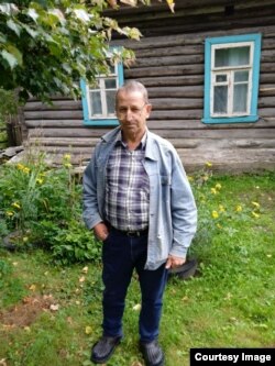 Александр Куроедов на фоне своего дома