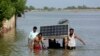 Flood victims use a cot to salvage belongings from their flooded home in Jaffarabad, Pakistan, on September 5.