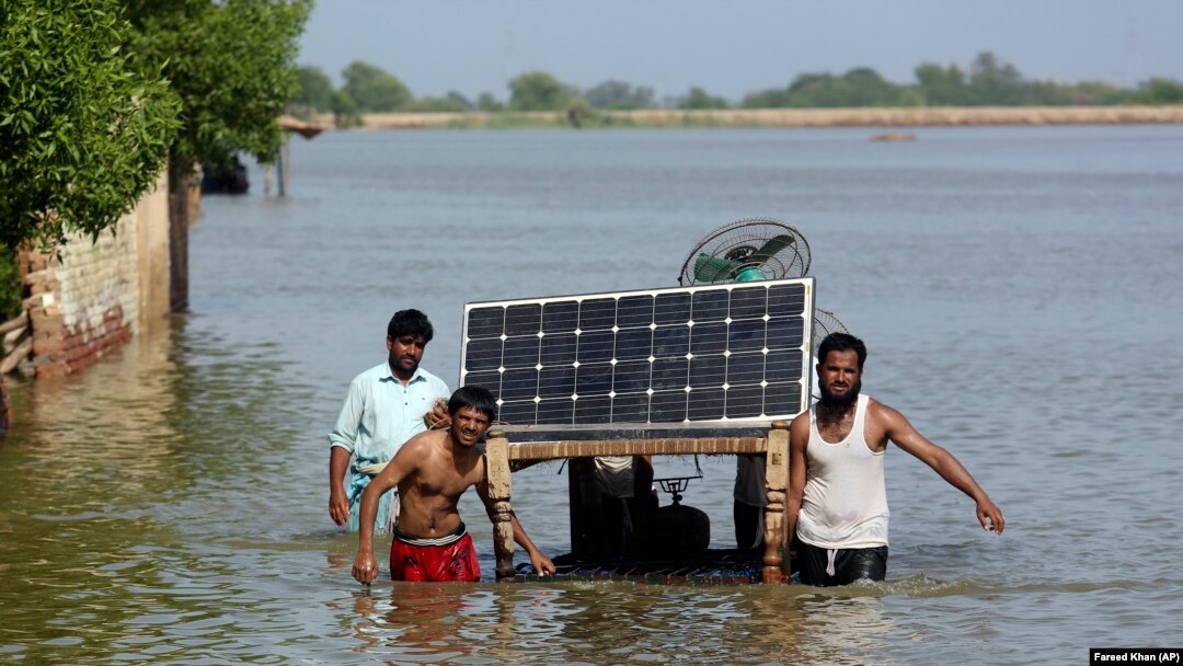 Flood victims use a cot to salvage belongings from their flooded home in Jaffarabad, Pakistan, on September 5.
