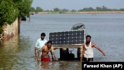 Flood victims use a cot to salvage belongings from their flooded home in Jaffarabad, Pakistan, on September 5.