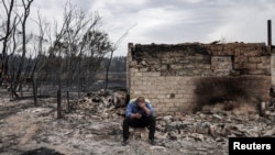 Житель Аманкарагая на руинах сгоревшего дома. 5 сентября 2022 года