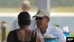 U.S. President Barack Obama chats with his wife, Michelle, during lunch at Lime's Bayside Bar and Grill in Panama City, Florida, on August 14.