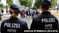 WATCH: Police officers watch demonstrators gathering to protest against the German asylum policy at the Ministry for Children, Family, Refugees and Integration of North Rhine-Westphalia (NRW) in Duesseldorf.