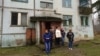 Ukrainian refugees stand outside one of the gloomy apartment buildings situated amid abandoned barracks at the former Russian air base in Smuravyevo. Local authorities are eager to see the 120 vacant flats rented out.