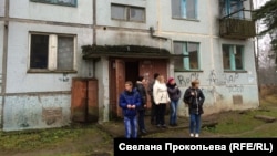 Ukrainian refugees stand outside one of the gloomy apartment buildings situated amid abandoned barracks at the former Russian air base in Smuravyevo. Local authorities are eager to see the 120 vacant flats rented out.