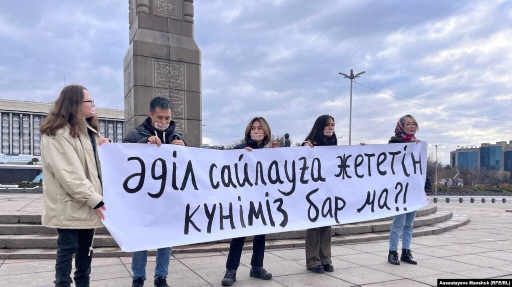 Активисты движения Oyan, Qazaqstan! на митинге на площади Республики в Алматы держат плакат, на котором написано: «Доживем ли до честных выборов?». 20 ноября 2022 года