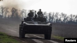 Украинские военнослужащие едут на боевой бронированной машине на передовой в Николаевской области, Украина, 4 ноября 2022 года