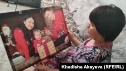 Жительница Усть-Каменогорска Арайлым Сагатбаева показывает фото своего сына с семьей