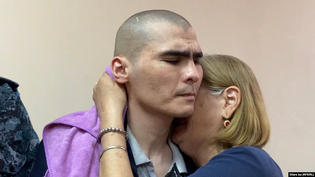 Kazakh opposition activist Erulan Amirov and his relative react to his sentencing in court on May 16.