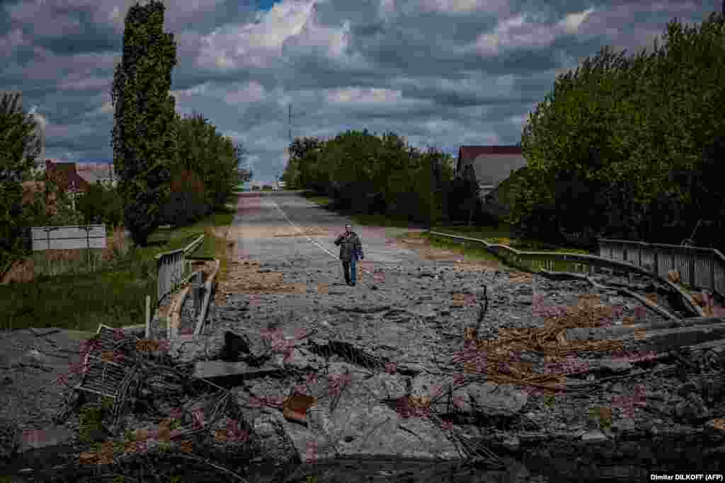 A man at a destroyed bridge on the road near the Ukrainian village of Rus&#39;ka Lozova, north of Kharkiv, on May 16.