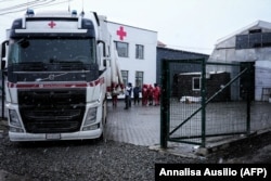 Сотрудники итальянского Красного Креста разгружают грузовик с неотложной помощью в Черновцах, 3 марта 2022 года