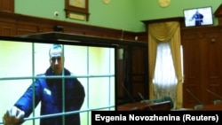 Russian opposition leader Alexei Navalny is seen on a screen via video link before a court hearing to consider an appeal against his prison sentence on May 17.