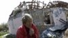Tatiana Poșivalova, în fața casei ei distruse din satul Vilhivka (foto REUTERS/Ricardo Moraes)