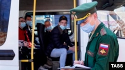 Russian conscripts board a shuttle bus at an army recruitment center before departing for military service. (file photo)