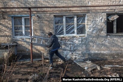 Një punëtor duke rregulluar dritaret e thyera në Novolhanske më 22 shkurt.