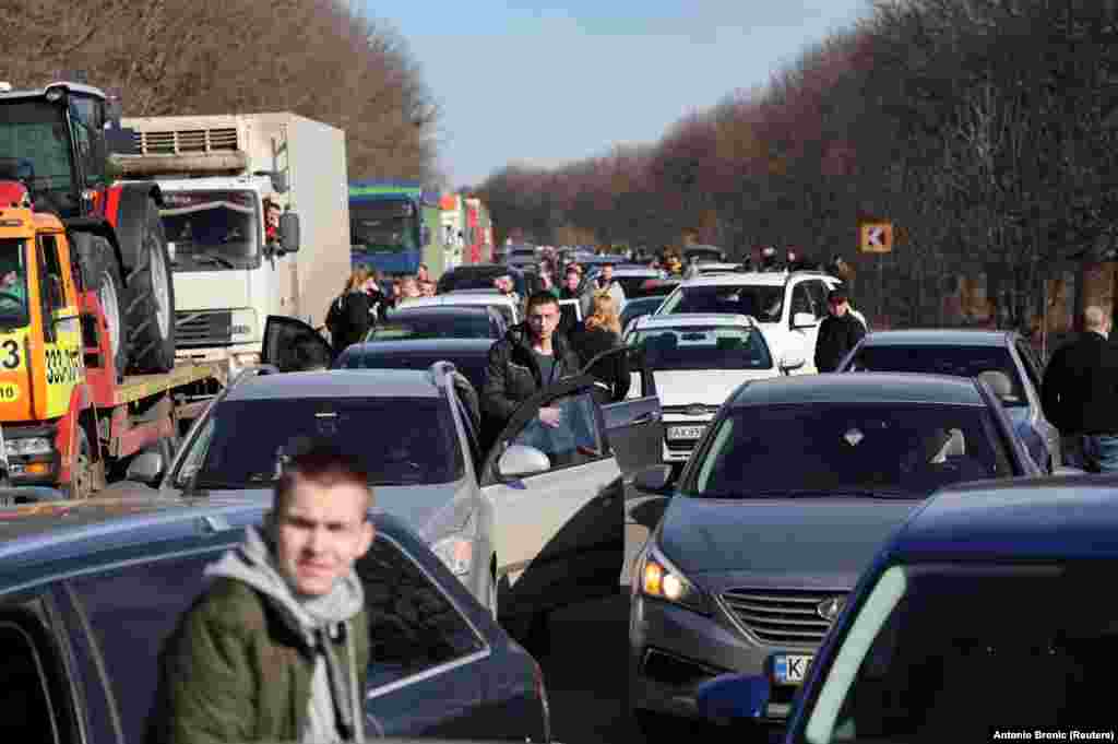 People wait in a traffic jam as they try to leave the eastern Ukrainian city of Kharkiv.&nbsp;