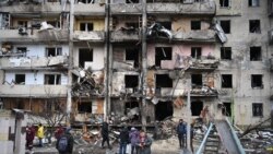 Ljudi se okupljaju ispred oštećene stambene zgrade u ulici Košica, 25. februara 2022.