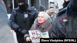 Российская полиция задерживает участницу антивоенного митинга в Петербурге, 24 февраля 2022 года