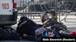 People take cover as an air-raid siren sounds in Kyiv on February 26.