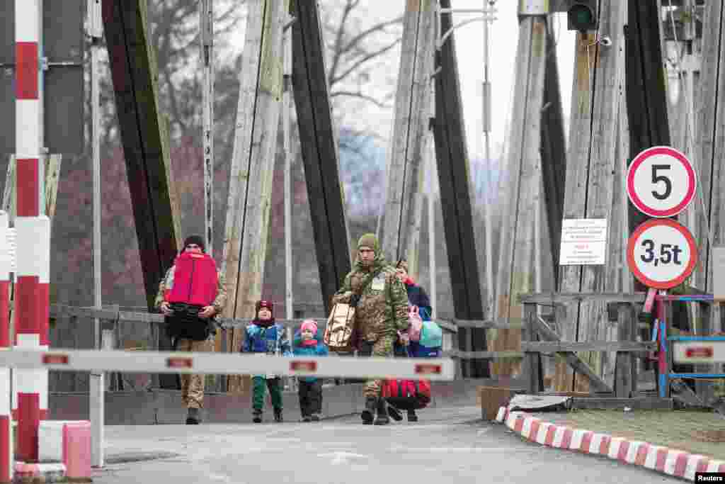 Ukrainian soldiers help a woman and children cross the border into Baia Mare, Romania, on February 26.