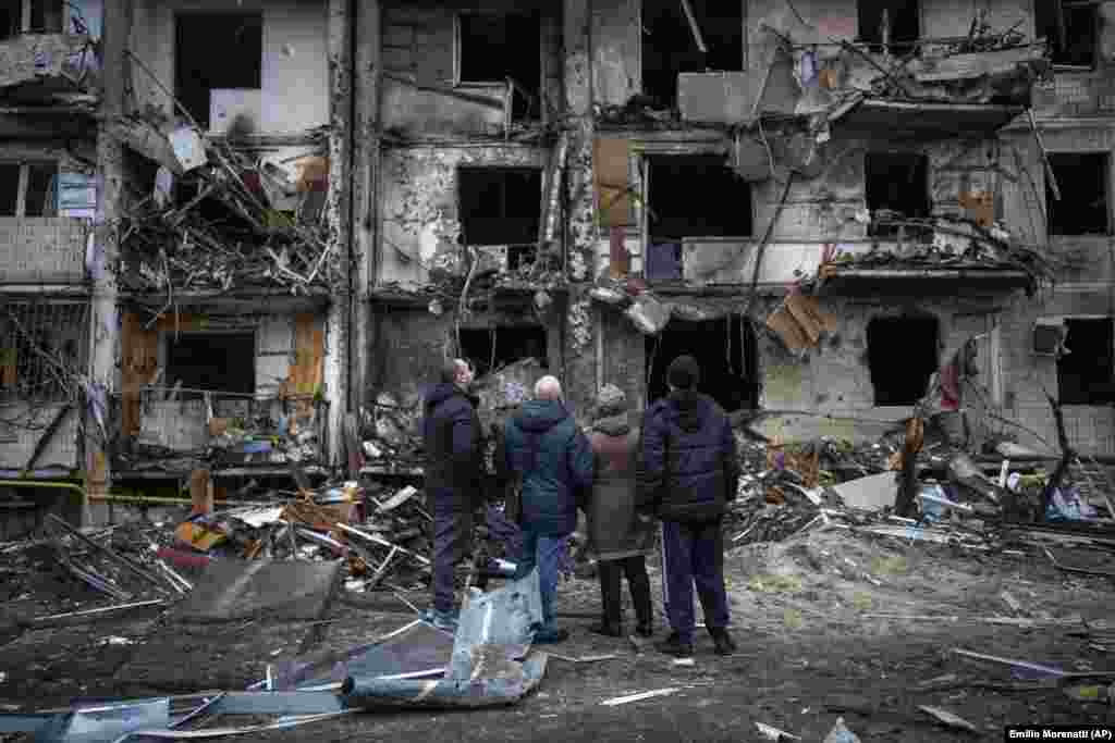 Locuitori din Kiev privesc urmările unui atac rusesc cu rachetă. 25 februarie 2022.