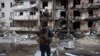 UKRAINE -- A person stands in front of a damaged residential building, after Russia launched a massive military operation against Ukraine, in Kyiv, Ukraine February 25, 2022. 