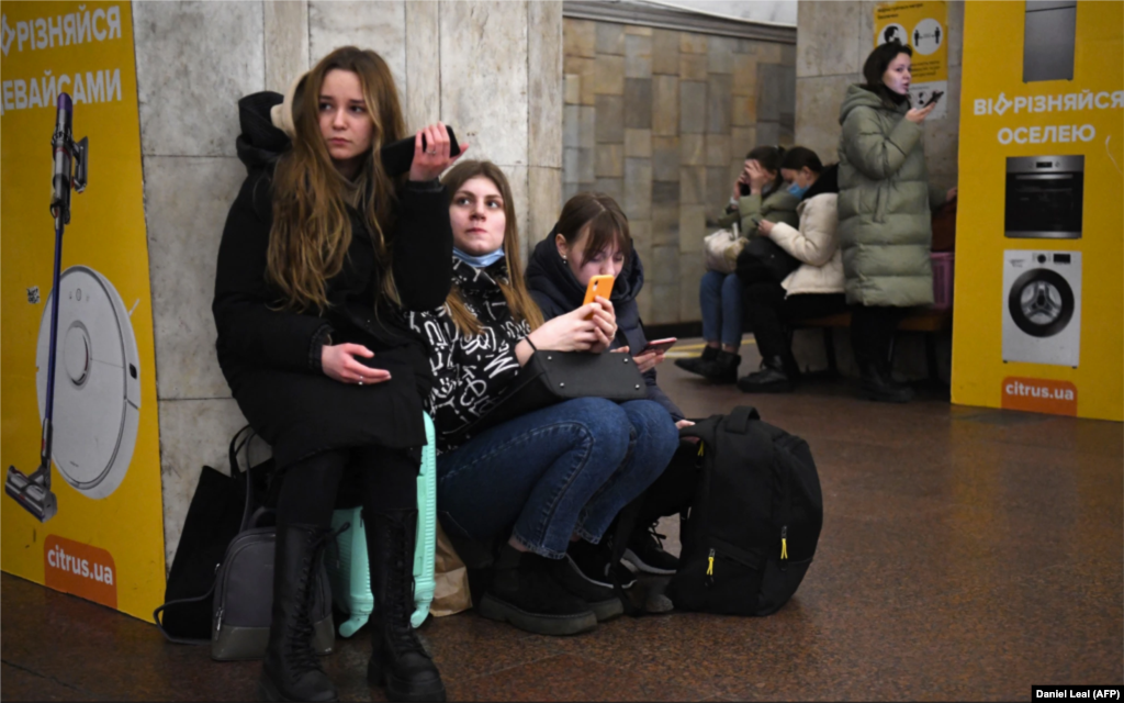Украинские девушки на станции метро в Киеве. В центре города звучали сирены воздушной опасности, когда города по всей Украине российские войска обстреляли ракетами и артиллерией