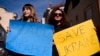 KOSOVO -- Women hold posters in support of Ukraine as they take part in a protest against the Russian invasion of Ukraine, in front of the Russian representative office in Pristina on February 25, 2022. 