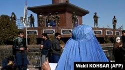 آرشیف، یک زن معترض افغان و شماری از طالبان مسلح
