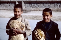 Деца, държащи прясно изпечен хляб в Исфахан.