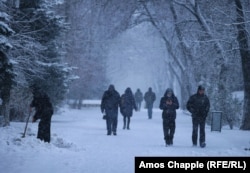 People walk through a morning snowstorm in Mariupol on February 6.