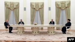 Vladimir Putin vorbește cu președintele Iranului, Ibrahim Raisi, la Kremlin, separați de o masă neobișnuit de lungă, 19 ianuarie 2022.
