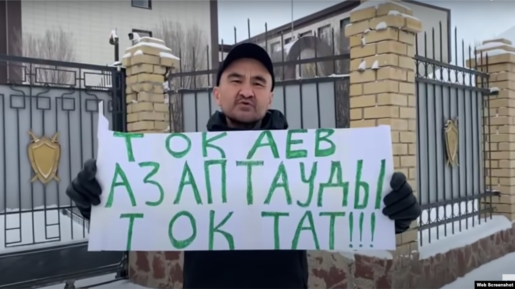 Гражданский активист Макс Бокаев с плакатом «Тоқаев, азаптауды тоқтат» («Токаев, прекрати пытки») перед зданием прокуратуры. Атырау, 14 января 2022 года