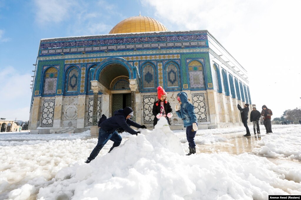 Fëmijët duke bërë një dordolec me borë para Kupolës së Shkëmbit, që ndodhet në qytetin e vjetër të Jerusalemit, në një kompleks të njohur për myslimanët si Shenjtorja Fisnike, kurse për hebrenjtë si Mali i Tempullit. 27 janar 2022.