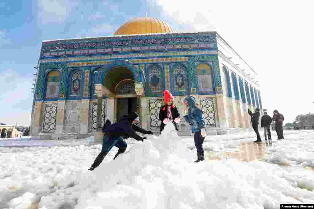 Djeca grade snjegovića ispred Kupole na stijeni, koja se nalazi u jeruzalemskom Starom gradu na kompleksu poznatom muslimanima kao Plemenito utočište, a Jevrejima kao Brdo hrama, 27. januar 2022.&nbsp;