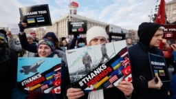Украинци с плакати "Благодарим, приятели", написан на различни езици на страни от НАТО, на централния площад в Киев, 30 януари 2022 г.