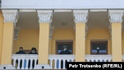 Милиция кызматкерлери митингди Казакстандын Улуттук илимдер академиясынын имаратынын балконунан көрүп жатышат. Алматы, 5-февраль, 2022-жыл.