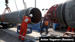 Workers are seen at a construction site of the Nord Stream 2 gas pipeline, near the town of Kingisepp, Russia, in June 2019. The pipeline is completed but had not yet begun operating while it waited for certification from German regulators.