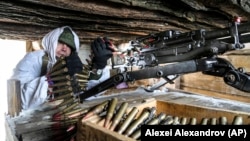 Украина әскери қызметкері елдің шығысындағы соғыс алаңында пулеметін тексеріп отыр. 27 қаңтар 2022 жыл.